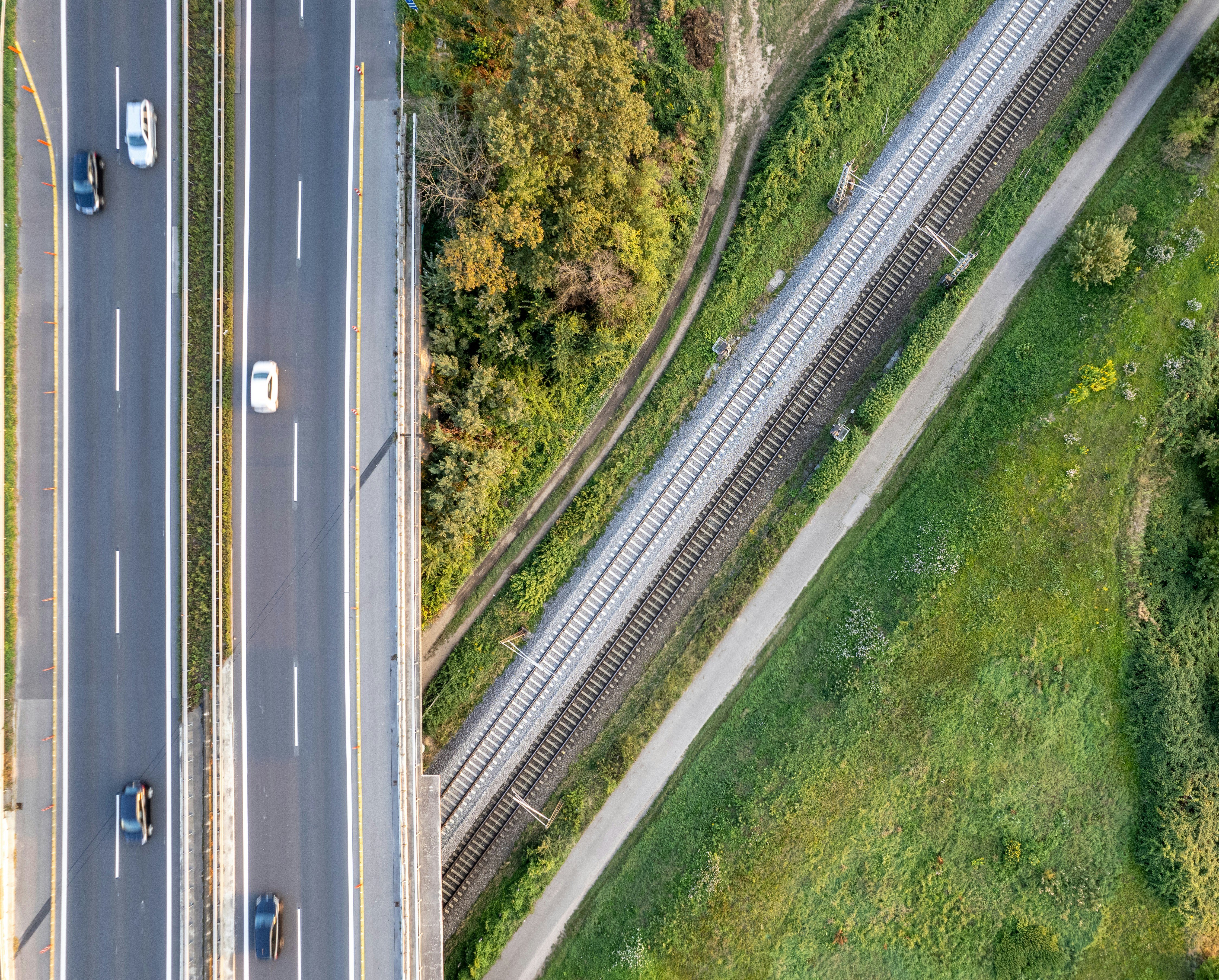 An aerial view of a motorway crossing over railway tracks